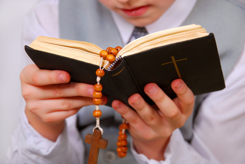 a young boy holds a Bible