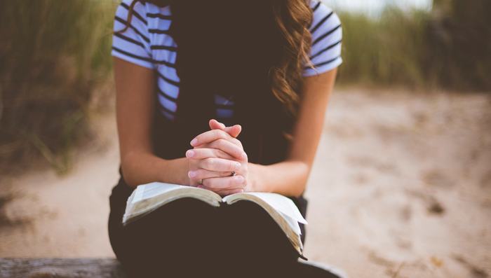 Girl praying with Bible